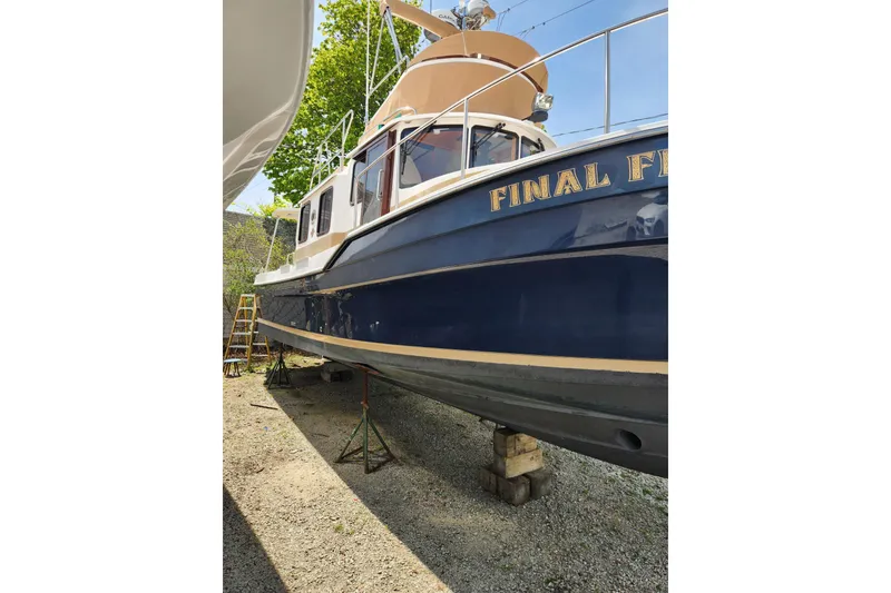 Slide: The Image of 2019 Ranger Tugs R-31 CB boat on stands, named "Final F," in a yard setting. - 3