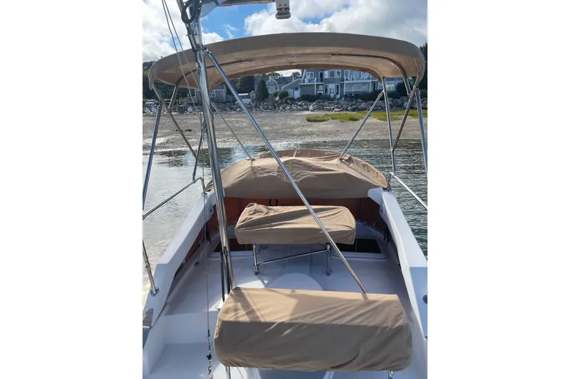 Slide: The Image of 2019 Ranger Tugs R-31 CB boat with covered seating, docked near a shoreline. - 31