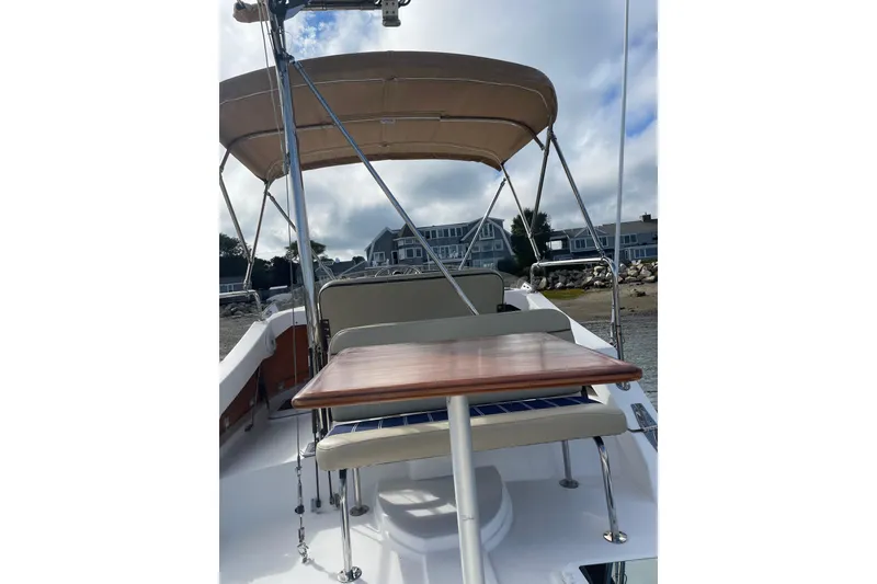 Slide: The Image of 2019 Ranger Tugs R-31 CB boat with canopy and seating, docked near waterfront homes. - 35