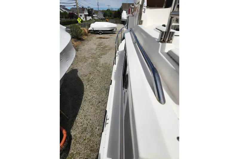 Slide: The Image of 2019 Ranger Tugs R-31 CB boat side view, parked outdoors on gravel. - 37