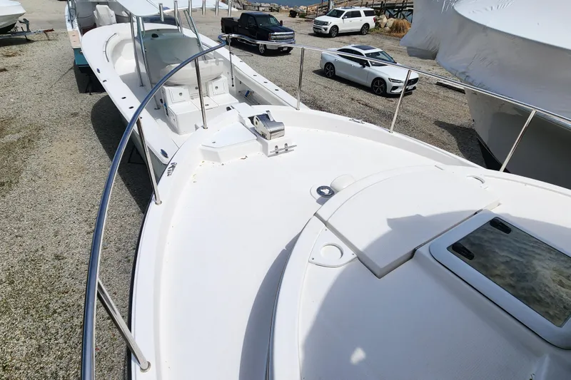 Slide: The Image of 2019 Ranger Tugs R-31 CB boat on display in a gravel lot with parked cars. - 38