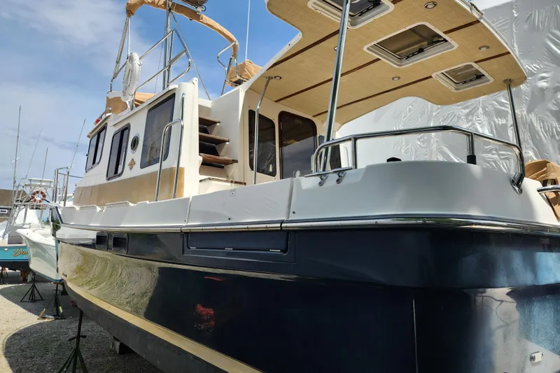 Slide: The Image of 2019 Ranger Tugs R-31 CB boat with blue hull and beige accents, docked outdoors. - 4