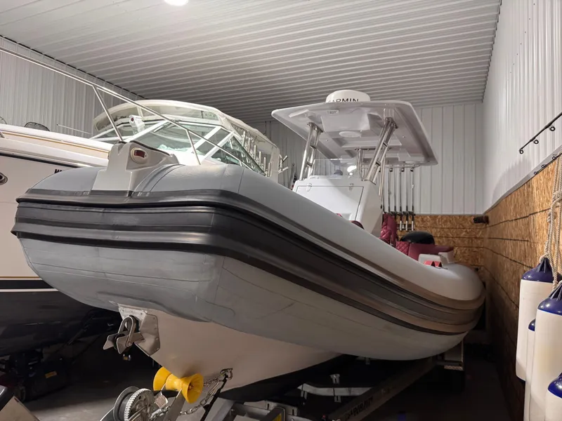 Slide: The Image of 2025 Apex A 24 boat stored indoors, side view. - 14