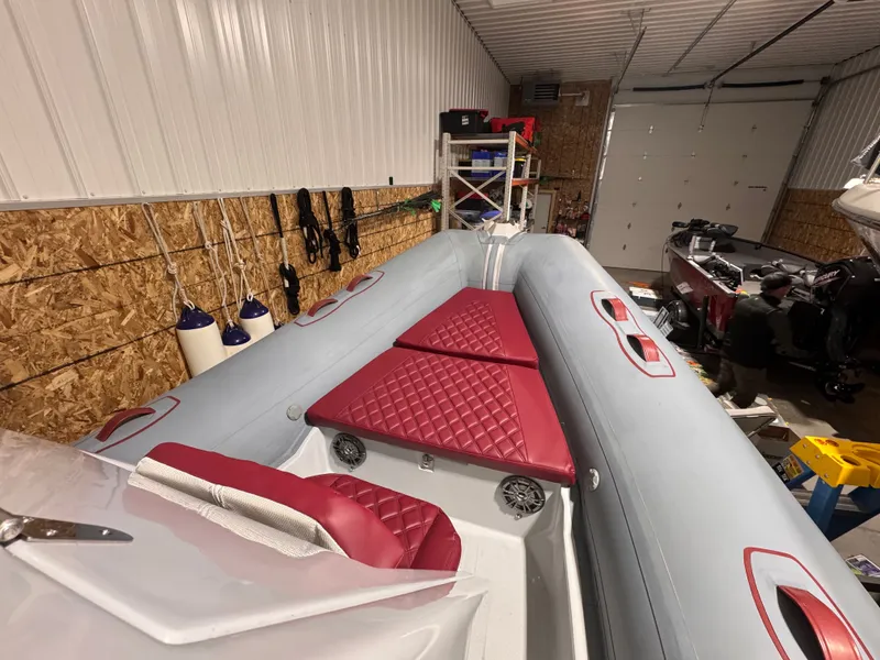 Slide: The Image of Apex A 24 boat 2025 in warehouse with red seats. - 6
