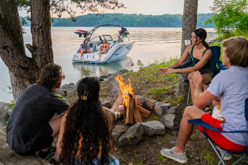 Slide: The Image of Group by campfire with Yamaha AR220 boat on lake, 2024 model. - 7
