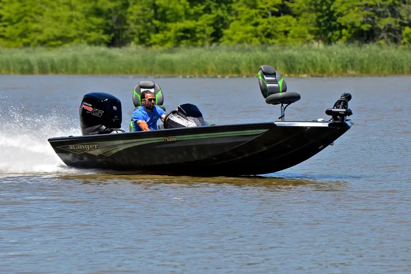 The Image of 2025 Ranger RT188 boat speeding on a lake with lush green background. - 1