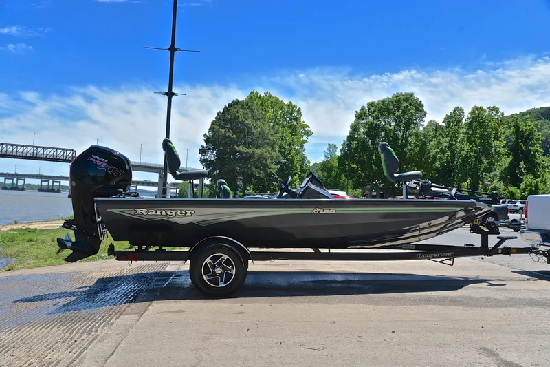 Slide: The Image of 2025 Ranger RT188 boat on trailer by riverside, under clear blue sky. - 15