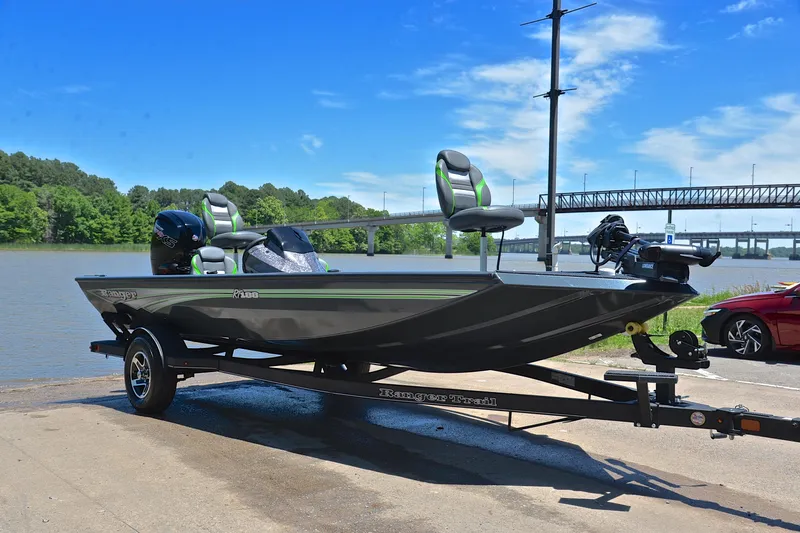 Slide: The Image of 2025 Ranger RT188 boat on trailer by a river, under a clear blue sky. - 16