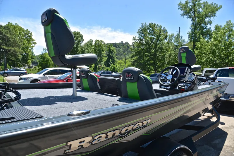 Slide: The Image of 2025 Ranger RT188 boat with green-accented seats, parked outdoors on a sunny day. - 19