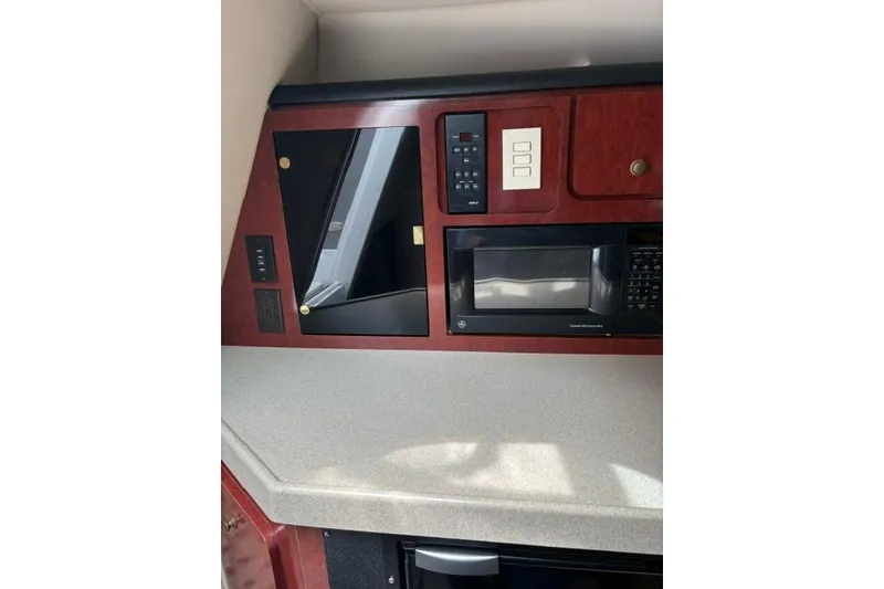 Slide: The Image of 2001 Wellcraft 3300 Martinique interior with microwave and control panel. - 12