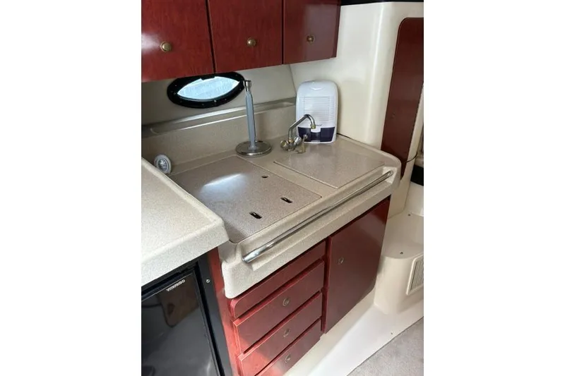 Slide: The Image of 2001 Wellcraft 3300 Martinique boat kitchenette with sink, cabinets, and countertop. - 13