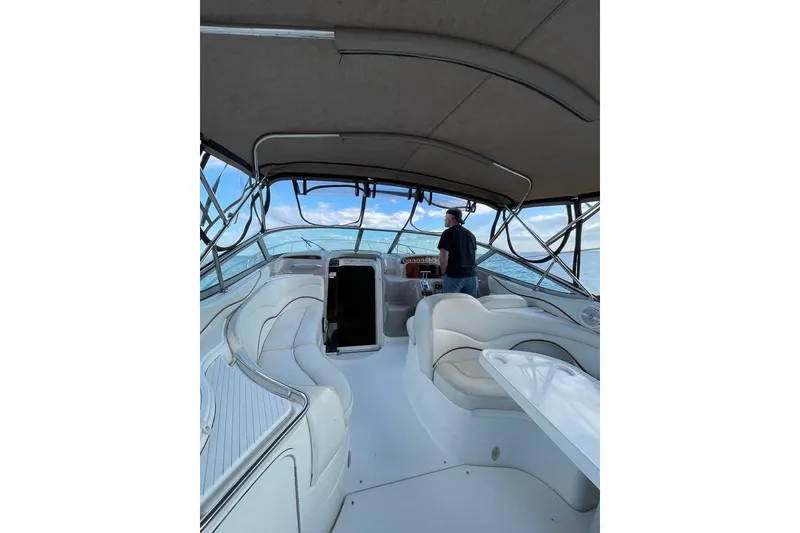 Slide: The Image of 2001 Wellcraft 3300 Martinique boat interior with seating and helm, cruising on open water. - 19
