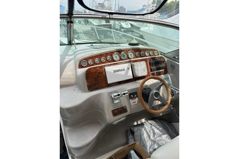 Slide: The Image of 2001 Wellcraft 3300 Martinique boat dashboard with Simrad navigation system and wooden steering wheel. - 6