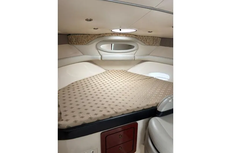 Slide: The Image of 2001 Wellcraft 3300 Martinique cabin interior with beige bedding and circular window. - 7