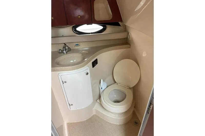 Slide: The Image of 2001 Wellcraft 3300 Martinique boat bathroom with sink, toilet, and storage cabinet. - 9