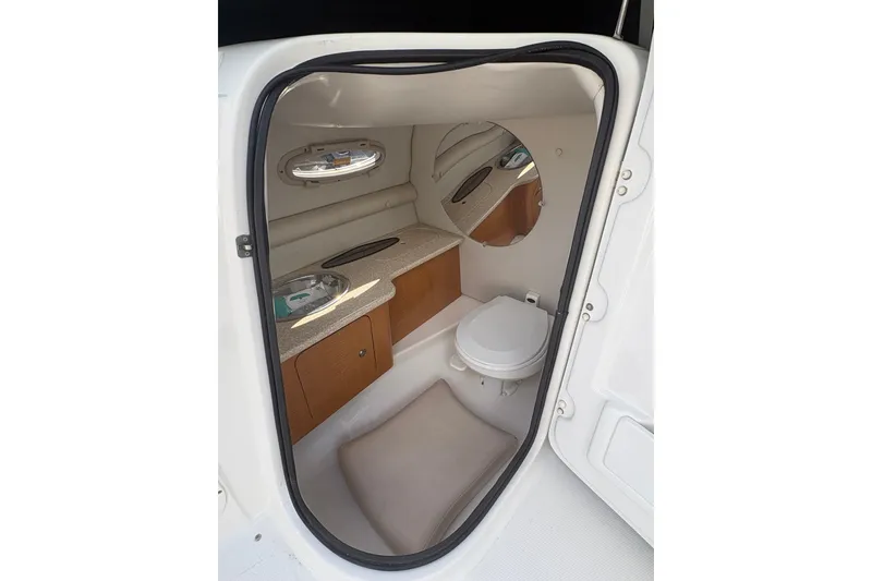Slide: The Image of 2006 Chaparral Sunesta 236 boat interior with toilet, sink, and mirror. - 10