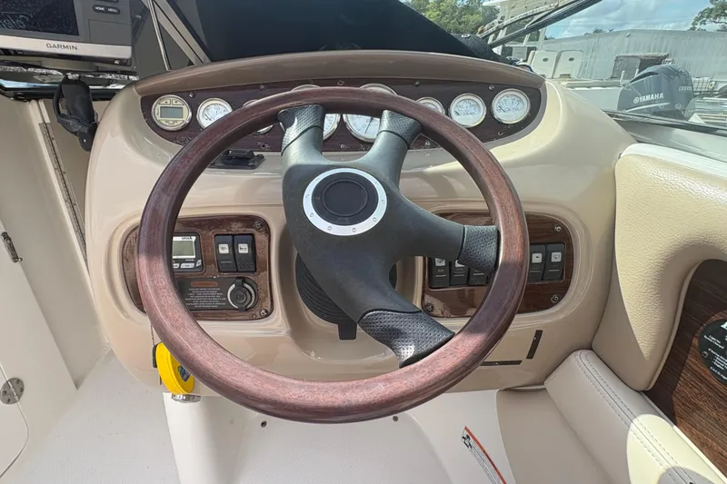 Slide: The Image of Steering wheel and dashboard of 2006 Chaparral Sunesta 236 boat with gauges and controls. - 13