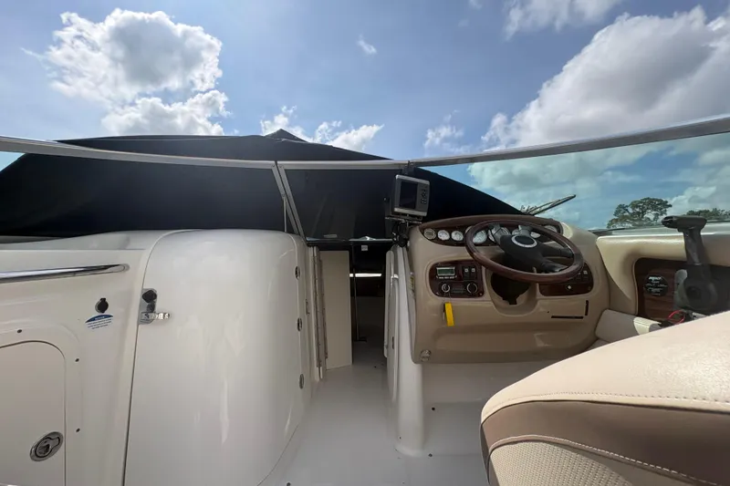 Slide: The Image of 2006 Chaparral Sunesta 236 boat cockpit with steering wheel and navigation equipment under blue sky. - 16