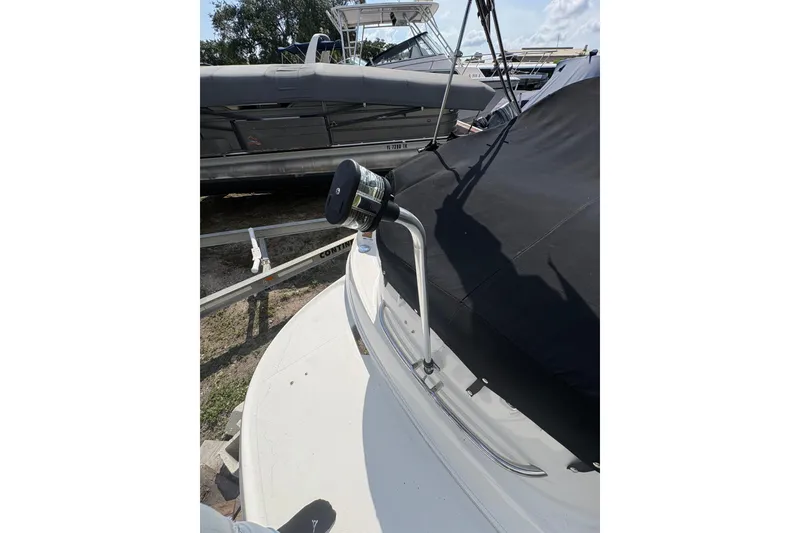 Slide: The Image of 2006 Chaparral Sunesta 236 boat with black cover and spotlight, docked outdoors. - 2