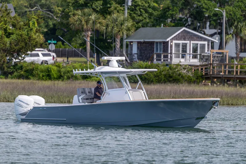 Slide: The Image of 2022 Valhalla Boatworks V-33 cruising on a calm waterway near a coastal house. - 10