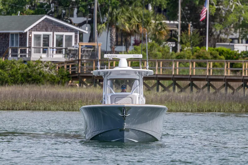 Slide: The Image of 2022 Valhalla Boatworks V-33 cruising on a serene waterway near a wooden dock. - 11