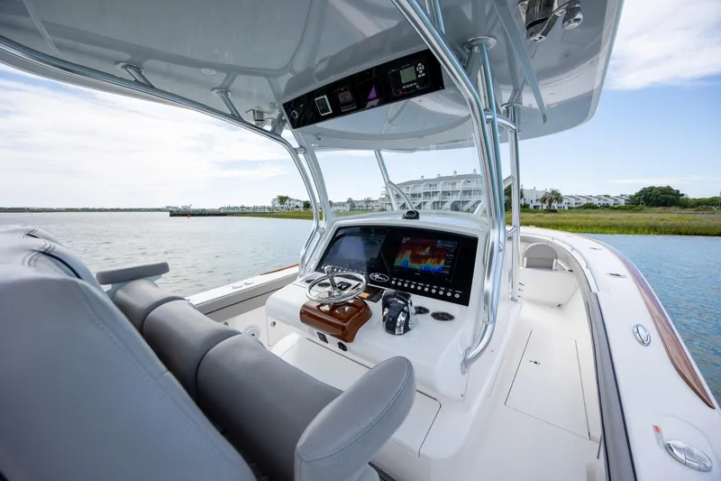Slide: The Image of 2022 Valhalla Boatworks V-33 helm with modern controls, cruising on a scenic waterway. - 24
