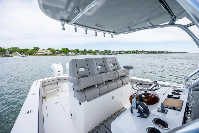 Slide: The Image of 2022 Valhalla Boatworks V-33 cockpit with luxurious seating and modern controls on a serene waterway. - 28