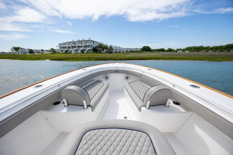 Slide: The Image of 2022 Valhalla Boatworks V-33 interior with elegant seating, cruising near waterfront buildings. - 30