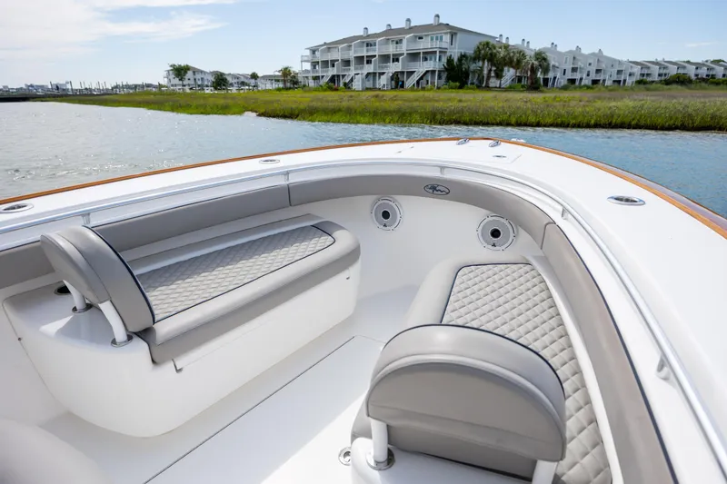 Slide: The Image of 2022 Valhalla Boatworks V-33 interior with luxurious seating, docked near waterfront homes. - 31
