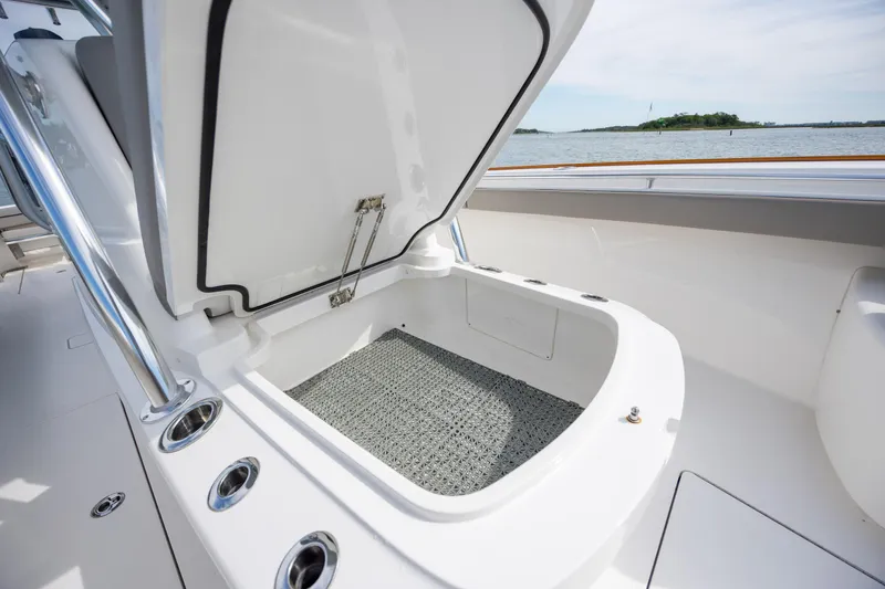 Slide: The Image of Open storage compartment on 2022 Valhalla Boatworks V-33, with ocean view background. - 34
