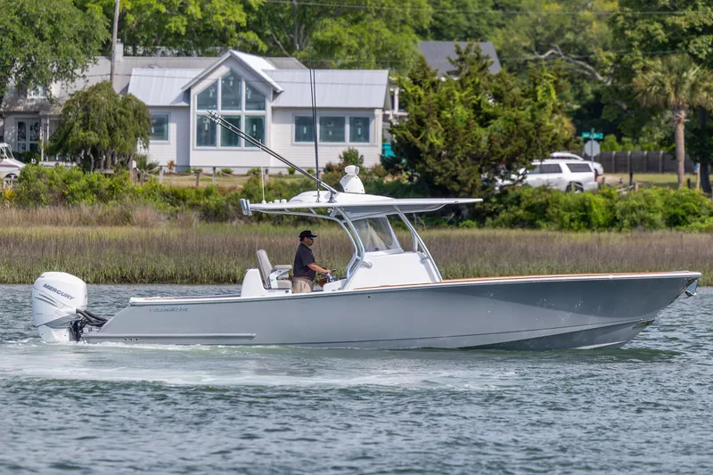 Slide: The Image of 2022 Valhalla Boatworks V-33 cruising on water near a coastal home. - 4