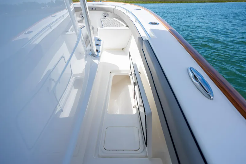 Slide: The Image of 2022 Valhalla Boatworks V-33 deck view with storage compartment open on calm water. - 44