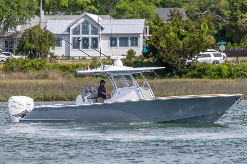 Slide: The Image of 2022 Valhalla Boatworks V-33 cruising on a calm waterway near a residential area. - 5