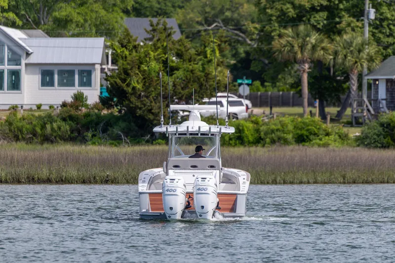 Slide: The Image of 2022 Valhalla Boatworks V-33 cruising on a scenic waterway near lush greenery. - 9
