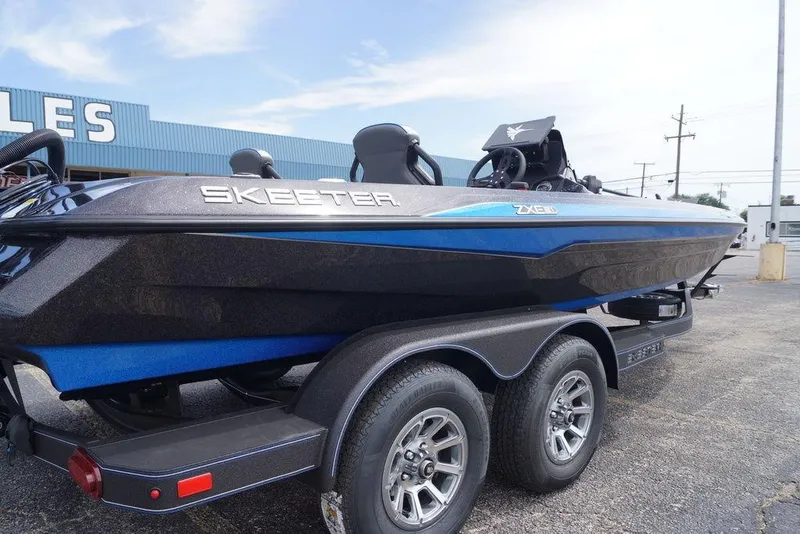 Slide: The Image of 2026 Skeeter ZXE21 boat on trailer, blue and black design, parked outdoors. - 11