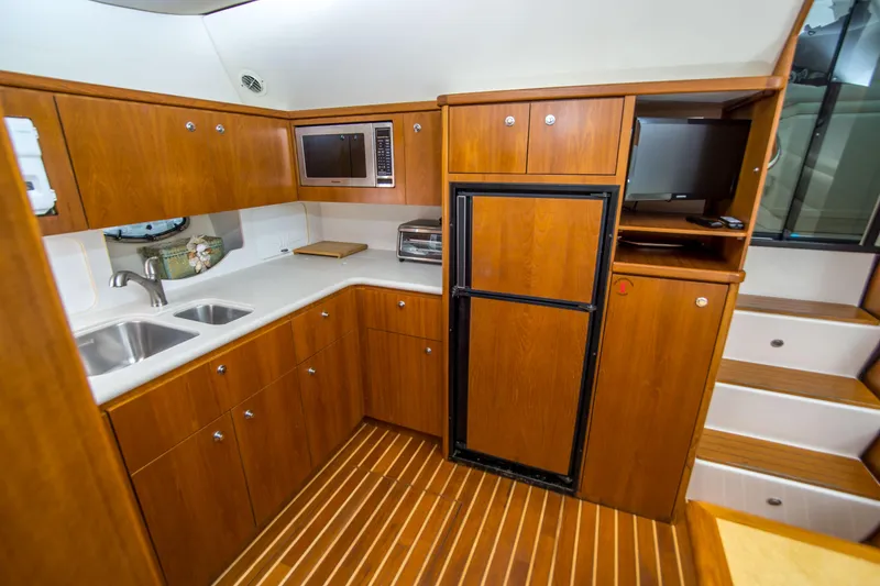 Slide: The Image of Luxurious 2002 Tiara Yachts 4100 Open kitchen with wood cabinetry and modern appliances. - 26