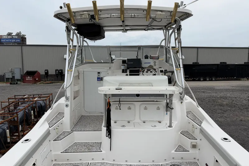 Slide: The Image of 2004 Pro Sports 2660 WA ProKat boat interior with fishing rod holders and steering console. - 12