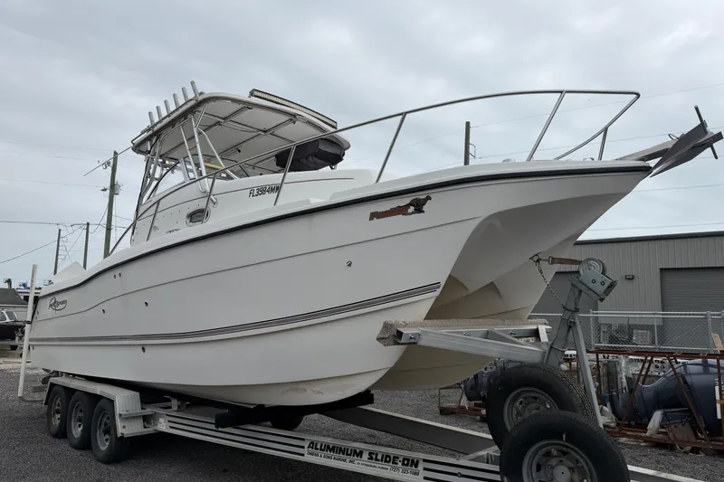 Slide: The Image of 2004 Pro Sports 2660 WA ProKat boat on trailer, parked outdoors. - 21