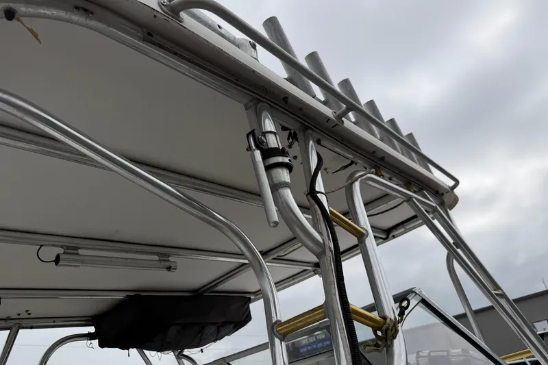 Slide: The Image of 2004 Pro Sports 2660 WA ProKat boat with metal framework and rod holders under cloudy sky. - 25
