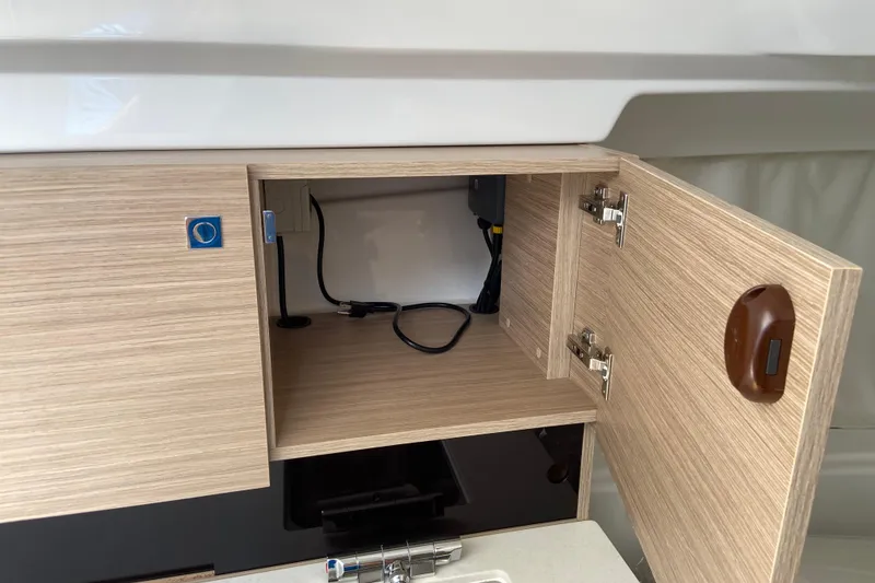 Slide: The Image of 2026 Jeanneau Leader 9.0 WA Series 2 interior cabinet with open door and visible wiring. - 35