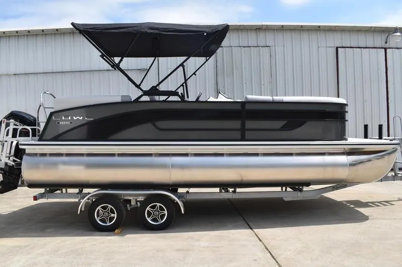 The Image of 2026 Lowe SS 230 WT Special pontoon boat with canopy on trailer, parked outdoors. - 1
