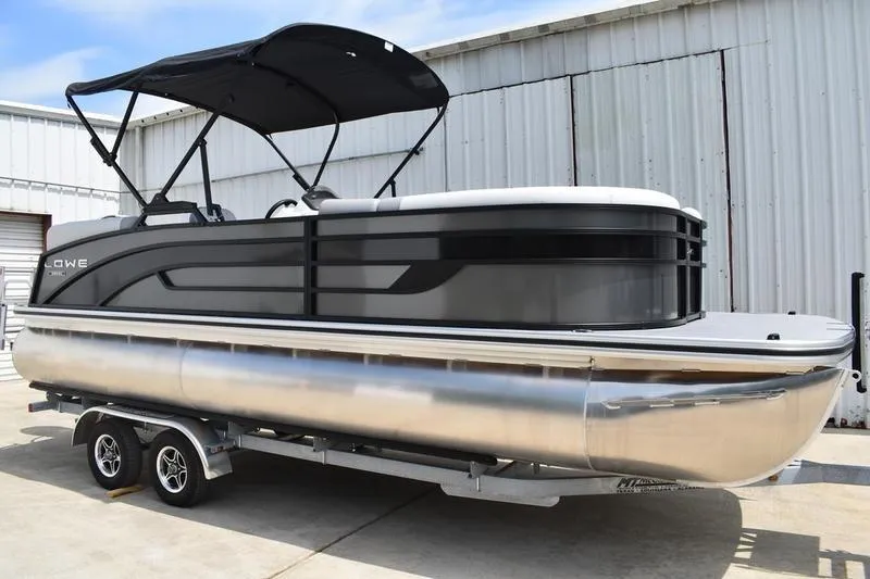Slide: The Image of 2026 Lowe SS 230 WT Special pontoon boat with canopy, parked on a trailer. - 3