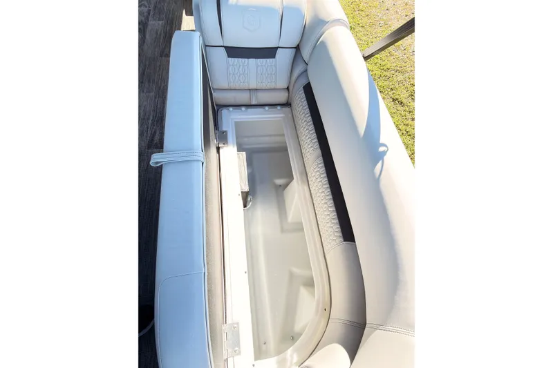Slide: The Image of 2021 Godfrey 2286 boat seat storage compartment, open and empty, with light upholstery. - 10