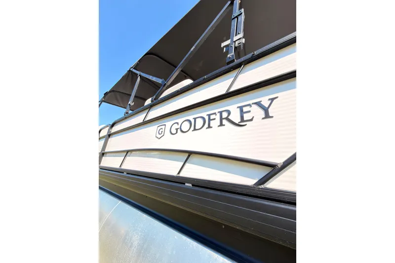 Slide: The Image of 2021 Godfrey 2286 boat with canopy against clear blue sky. - 11