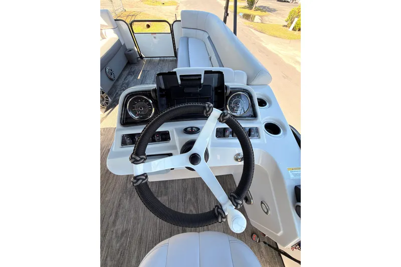 Slide: The Image of Steering console of a 2021 Godfrey 2286 boat with modern controls and seating. - 17