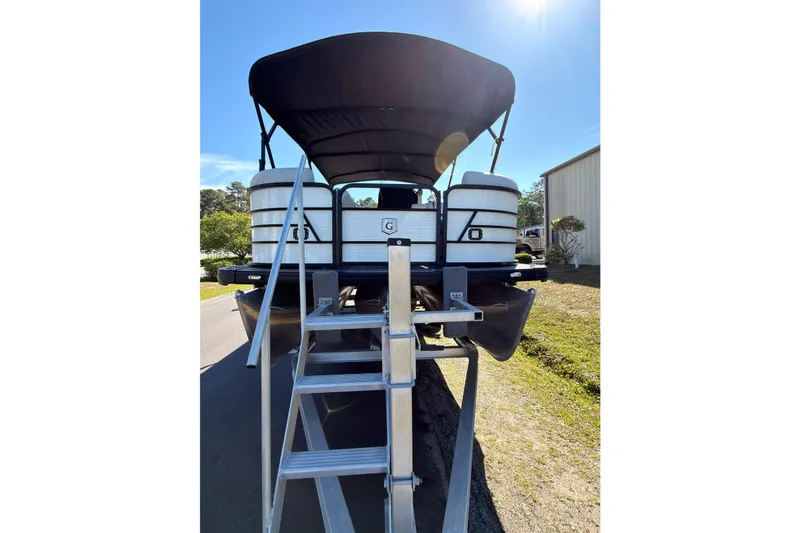 Slide: The Image of 2021 Godfrey 2286 pontoon boat with canopy and ladder, parked outdoors. - 6