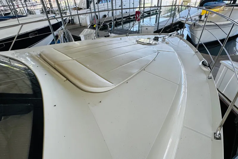 Slide: The Image of 2006 Carver 46 Voyager yacht deck with cushioned seating, docked in a marina. - 13