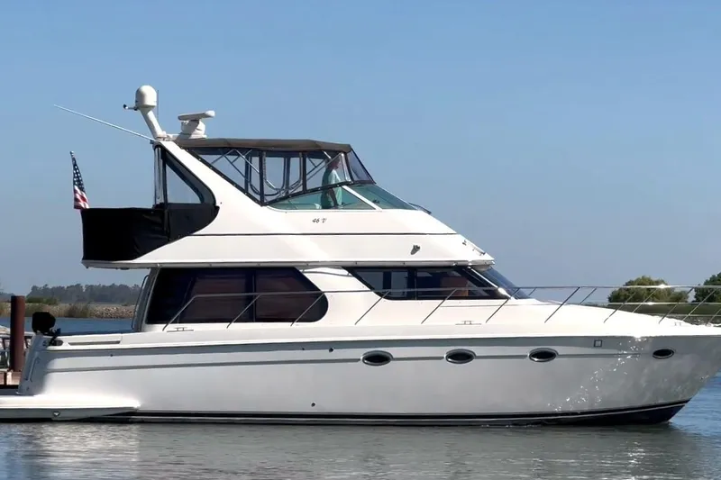 Slide: The Image of 2006 Carver 46 Voyager yacht on calm water, side view with clear sky. - 2