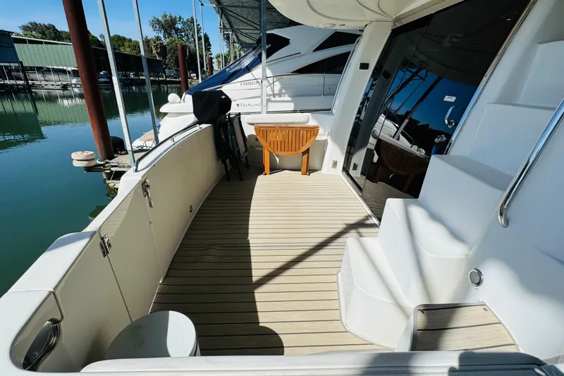 Slide: The Image of 2006 Carver 46 Voyager yacht deck with seating, docked by calm waters. - 20