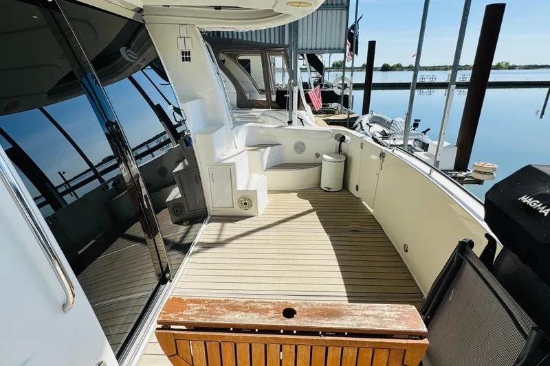 Slide: The Image of 2006 Carver 46 Voyager yacht deck with seating, docked by calm waters. - 21